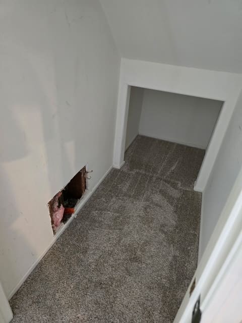 Single low access cut inside the under stair closet exposing the leaking pipes