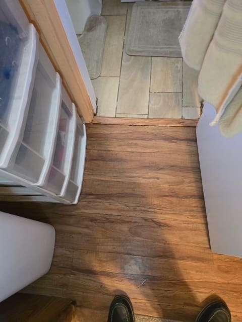 Bathroom threshold and hallway flooring affected by hidden moisture in San Bernardino